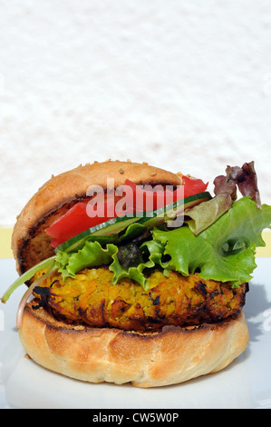 Vegetarische Kichererbsen, Mais und Karotten-Burger mit Salat in einem Sesam Brötchen, UK. Stockfoto