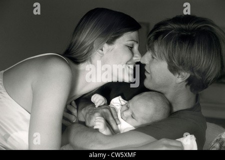 Paar in romantische Stimmung mit Baby schläft zwischen ihnen im Bett im Morgenlicht Stockfoto