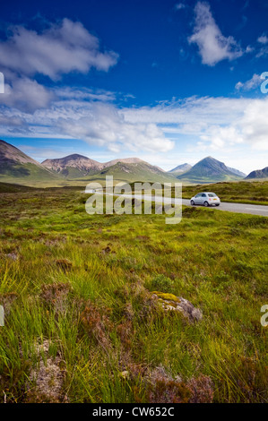 Ein Auto fahren durch die red Cuillin Mountains in der Nähe von Sligachan auf der Insel Skye, Schottland, Großbritannien Stockfoto