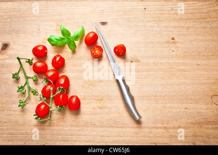 Frische Tomaten und Basilikum auf ein Schneidebrett Stockfoto