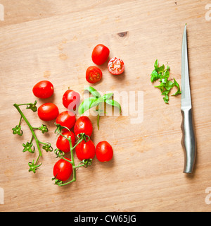 Frische Tomaten und Basilikum auf ein Schneidebrett Stockfoto