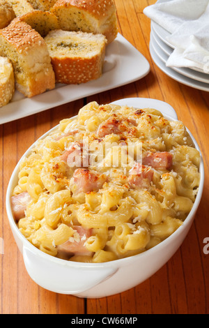 Makkaroni-Käse mit Schinken, serviert mit Knoblauchbrot. Eine gute Möglichkeit Ihre Weihnachtsschinken aufzubrauchen. Stockfoto