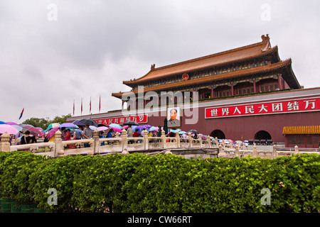 Touristen, die bergende unter Sonnenschirmen Stream in die Verbotene Stadt an einem regnerischen Sommertag in Peking, China Stockfoto