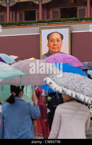 Touristen, die bergende unter Sonnenschirmen Stream in die Verbotene Stadt an einem regnerischen Sommertag in Peking, China Stockfoto