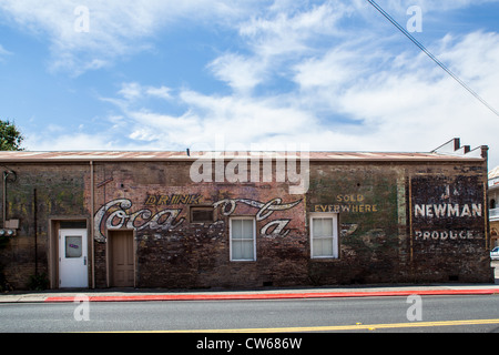 Ein altes Coca Cola Schild zusammen mit einigen anderen in Ione Kalifornien Stockfoto