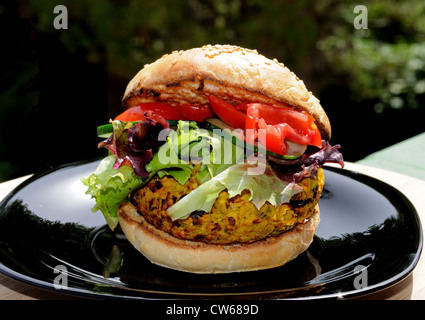 Vegetarische Kichererbsen, Mais und Karotten-Burger mit Salat in einem Sesam Brötchen, UK. Stockfoto