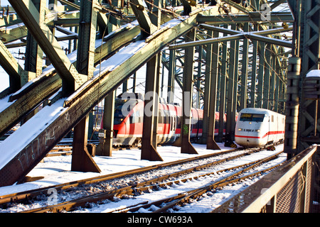 Züge auf der Hohenzollernbrücke in Schnee, Deutschland, Nordrhein-Westfalen, Köln Stockfoto