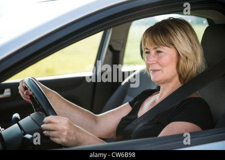 Porträt von attraktiven senior lächelnde Frau sitzen im Auto Stockfoto