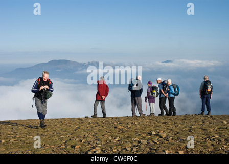 Gruppe der Wanderer auf dem Gipfel des Felsen Hill, Lake District, blickte auf die Cloud. Stockfoto