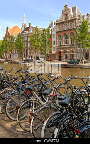 Fahrräder parken auf eine Gracht in der Innenstadt von Amsterdam, Niederlande Stockfoto