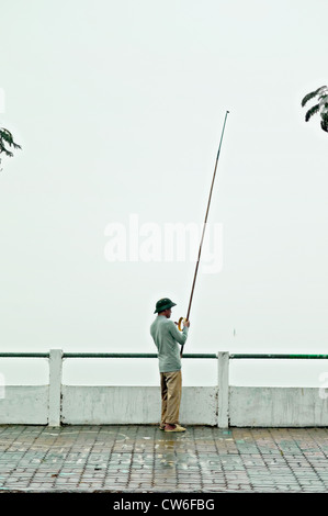 Ein einsamer Angler am am Westsee in Hanoi, Vietnam Stockfoto