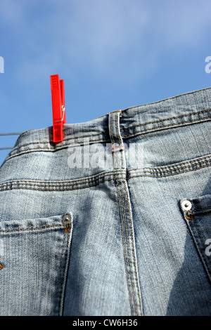 Jeans auf einer Wäscheleine draußen trocknen Stockfoto