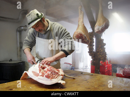 Strahlende Dorf, ein Mann in ein Schwein schneiden Stockfoto