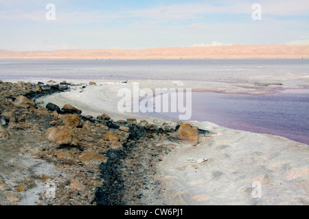 Salzsee Chott el-J befreien mit roten Wasser und Straße überqueren den See, Atlas-Gebirge im Hintergrund, Tunesien, Chott el-J zu befreien, Tozeur Stockfoto