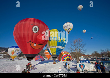 Heißluft-Ballon-Festival auf einem Schneefeld mit mehreren Ballons in Vorbereitung für den Start oder abgenommen haben und eine Menge von Zuschauern, Oberstdorf, Allgäu, Bayern, Deutschland Stockfoto