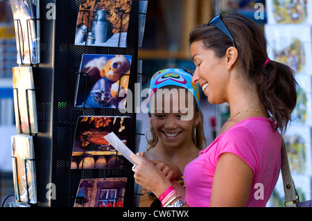 Tochter und Mutter mit fun-Auswahl Postkarten aus einer Postkarte Stand, Frankreich Stockfoto