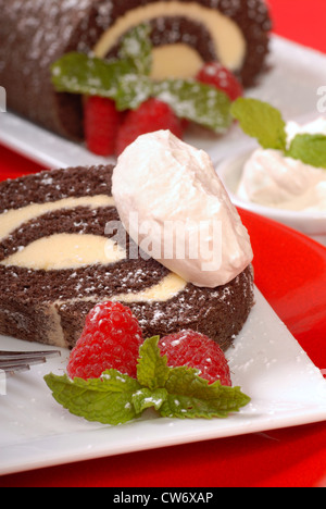 Leckeres Weihnachten Buche de Noel-Kuchen mit Himbeeren, Schlagsahne Sahne und Puderzucker Stockfoto