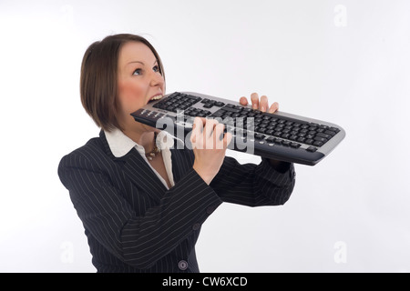 Business Frau beißt in Tastatur Stockfoto