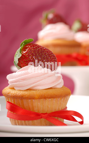 Köstliche Vanille Cupcake Erdbeer Glasur mit einer frischen Erdbeere Stockfoto