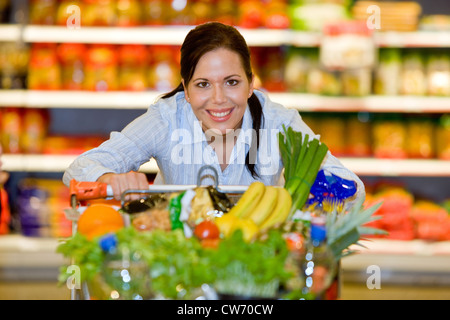 junge Frau im Supermarkt kauft Lebensmittel und Früchte Stockfoto