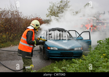 Ausbildung von Feuerwehr und Sanitäter bei einem Unfall mit einem brennenden Auto Stockfoto