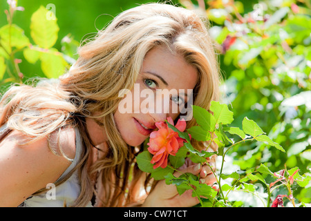 Frau eine Rose im Garten riechen Stockfoto