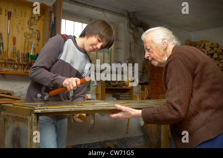 Großmutter und Enkel tun Holzarbeiten zusammen in der Werkstatt Stockfoto