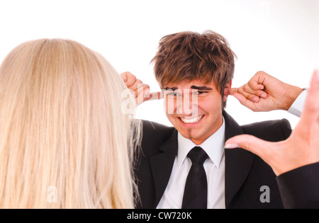 Mann und Frau streiten, er klebt die Finger in die Ohren Stockfoto