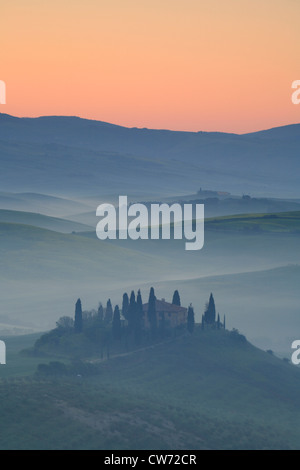 typische Hügellandschaft der Toskana mit Getreidefeldern, Zypressen und Haus Morgen Nebel, Italien, Toskana Stockfoto