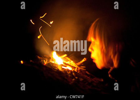 Junge am Lagerfeuer, weht in der Hitze Stockfoto