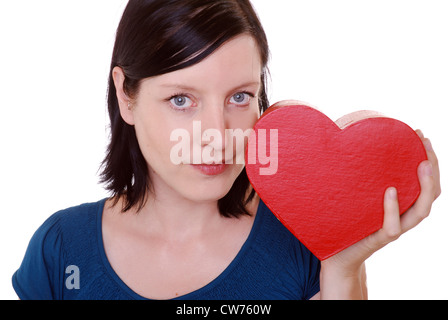 Frau schaut nachdenklich und hat eine Heartgiftbox in der hand Stockfoto