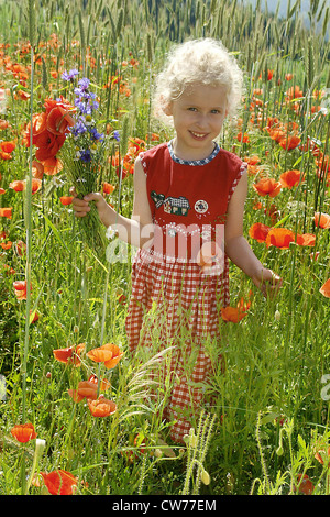 kleines Mädchen in einem Feld von Mohn Stockfoto