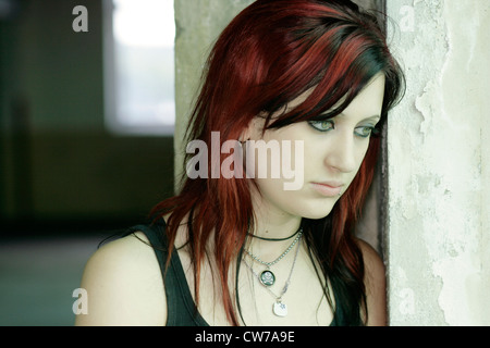 junge Frau lehnt sich an die Wand der Fabrikhalle, Porträt, Deutschland Stockfoto