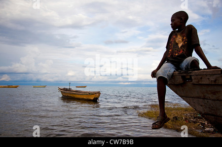 Junge sitzt auf Fischerboot am Tanganjikasee, Burundi, Makamba, Mvugo, Nyanza Lac Stockfoto