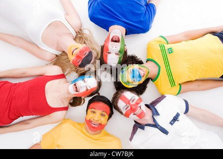 internationale junge Menschen mit aufgemalten Gesichtern in Nationalfarben Stockfoto