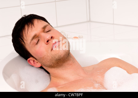 attraktive junge Mann in einer Badewanne entspannen Stockfoto