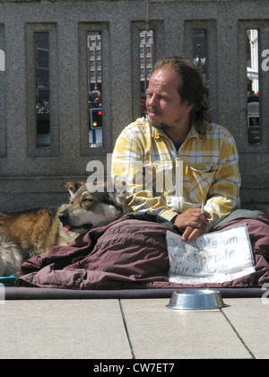 Obdachloser mit Hund bittet Geld auf einer Brücke über der Alster in der Stadt Hamburg, Deutschland, Hamburg um Stockfoto