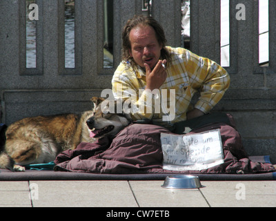 Obdachloser mit Hund bittet Geld auf einer Brücke über der Alster in der Stadt Hamburg, Deutschland, Hamburg um Stockfoto