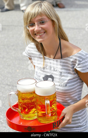 Kellnerin mit Bier auf einem Tablett Stockfoto