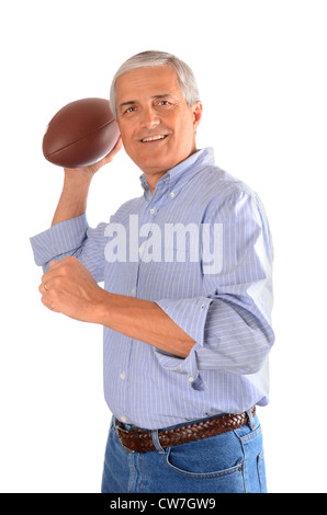 Im mittleren Alter Geschäftsmann in Jeans und Kleid Shirt werfen ein American Football. Hochformat, isoliert auf weiß. Stockfoto