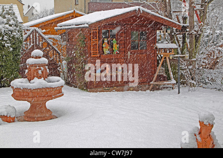 verschneiten Garten mit Gartenhaus im Schneegestöber, Deutschland Stockfoto