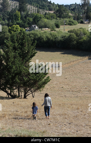 Eine Frau und Kind zu Fuß in ein Feld. Stockfoto