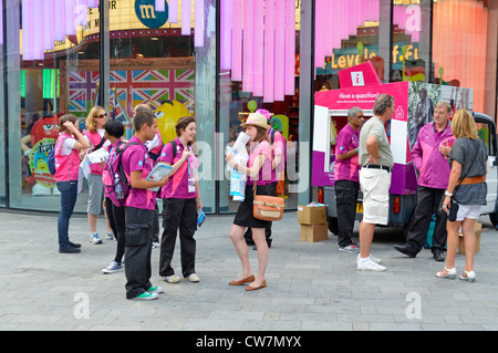 London 2012 Freiwillige in offizieller Uniform stehen während der Olympischen Spiele in Leicester Square England zur Verfügung, um Fragen zu beantworten und Informationen zu geben Stockfoto