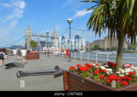 Thames Path Butlers Wharf auf der Themse mit Blick auf Tower Bridge und Londoner Skyline Blüten am Wasser in Pflanzkästen und cordyline Trees London UK Stockfoto