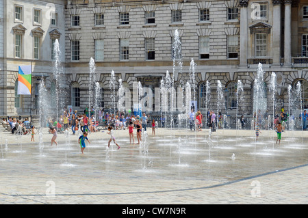 Familien genießen den Innenhof tanzenden Fontänen im Somerset House an einem heißen Sommertag südlichen Seite von The Strand London England Großbritannien Stockfoto