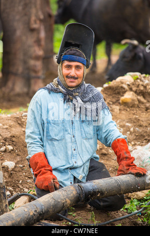 Mann Schweißen eine Grundleitung in Said Pur Dorf, Islamabad, Pakistan Stockfoto