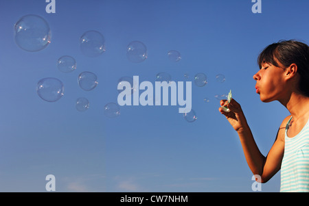 Das hübsche kleine Mädchen bläst Seifenblasen Stockfoto