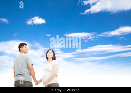 Mann hält schwangere Frau Hand und Cloud-Hintergrund Stockfoto