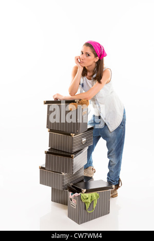 Unentschlossen Frau ruht und stützte sich auf einen Stapel von gestreiften Boxen. Stockfoto