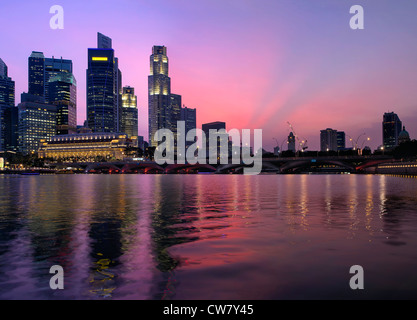 Skyline von Singapur Central Business District entlang Fluss und Esplanade Bridge in der Dämmerung Stockfoto